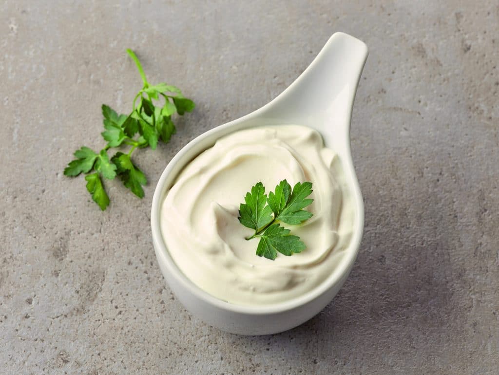 bowl of sour cream on grey surface, top view