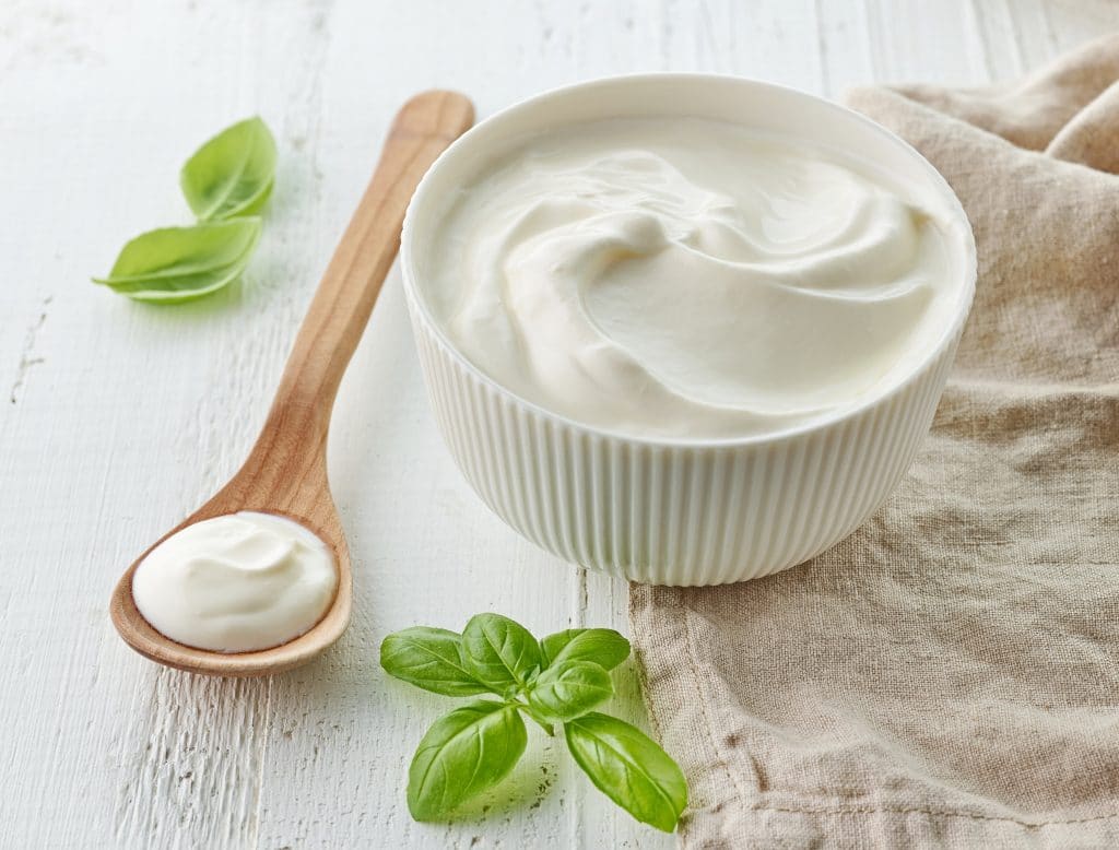bowl of sour cream on white wooden table