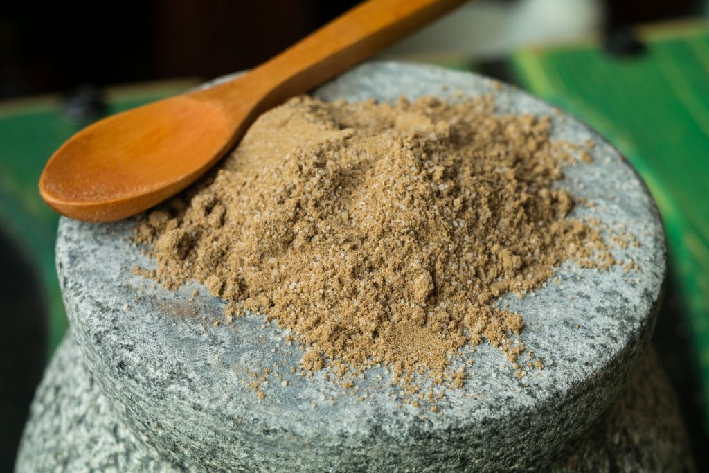 salt with celery and a wooden spoon on a ceramic bowl